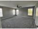 Large bedroom featuring gray walls, carpeted floor, and natural light from the windows at 8048 Garden Ridge Rd, Indianapolis, IN 46237