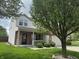 Well-maintained two-story home featuring a brick facade, a two-car garage, and a cozy front porch surrounded by a green lawn at 8048 Garden Ridge Rd, Indianapolis, IN 46237