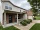 Charming two-story home with a brick and vinyl exterior, a covered front porch, and attached garage at 8048 Garden Ridge Rd, Indianapolis, IN 46237