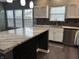 This kitchen features a beautiful island, white cabinetry, stainless steel appliances, and dark backsplash at 8048 Garden Ridge Rd, Indianapolis, IN 46237