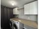 Efficient laundry room features cabinets, long countertop, and modern washer and dryer units at 8048 Garden Ridge Rd, Indianapolis, IN 46237