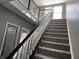 Carpeted staircase with black and white banister, complemented by natural light and neutral walls at 8048 Garden Ridge Rd, Indianapolis, IN 46237