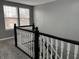 Carpeted staircase with black and white railing ascending to the upper floor and a window at the landing at 8048 Garden Ridge Rd, Indianapolis, IN 46237