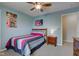 Well-lit bedroom featuring a ceiling fan, a bed with colorful sheets and pillows, and an end table with drawers at 8218 Elsen Ridge, Avon, IN 46123