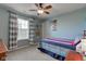 This bedroom features a ceiling fan, a window with blinds, and a bed with colorful sheets and pillow at 8218 Elsen Ridge, Avon, IN 46123