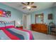 This bedroom features a ceiling fan, a bed with colorful sheets and pillows, and a dresser with a mirror at 8218 Elsen Ridge, Avon, IN 46123