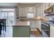 Kitchen with stainless steel appliances, light countertops, white cabinets, and a center island overlooking the patio at 8218 Elsen Ridge, Avon, IN 46123