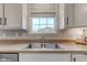 A stainless steel kitchen sink with a window view and white cabinets at 8218 Elsen Ridge, Avon, IN 46123