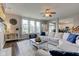 Bright living room features a ceiling fan, hardwood floors, large windows, and a comfortable sectional sofa at 8218 Elsen Ridge, Avon, IN 46123