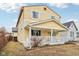 A cozy yellow home showing the side and front porch at 854 W Roache St, Indianapolis, IN 46208