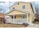 Side view of a yellow two-story home with a cozy front porch and manicured lawn at 854 W Roache St, Indianapolis, IN 46208