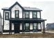 Two-story house features black trim, Tyvek house wrap, and a covered porch, showcasing its modern design and construction phase at 9345 Anthem Ave, Plainfield, IN 46168