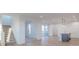 Open-concept living space with staircase, hardwood floors, and view of the kitchen at 9345 Anthem Ave, Plainfield, IN 46168