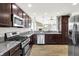 Modern kitchen with stainless steel appliances, granite countertops, and dark wood cabinets at 1393 N Salem Ct, Greenfield, IN 46140