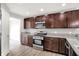 This kitchen features stainless steel appliances, granite countertops, and dark wood cabinets at 1393 N Salem Ct, Greenfield, IN 46140