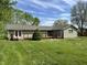 Home featuring large backyard with wood deck and well-maintained lawn at 1435 E New Rd, Greenfield, IN 46140