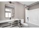Modern bathroom featuring black fixtures, sleek mirror, white vanity with large sink, and white shower-tub combo at 1517 E New York St, Indianapolis, IN 46201