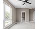 Comfortable bedroom boasts a ceiling fan, carpet flooring, and large windows at 1517 E New York St, Indianapolis, IN 46201