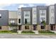 Exterior of modern townhouses showcasing a sleek design with a small deck and lush green lawn at 1517 E New York St, Indianapolis, IN 46201