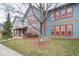Townhome exterior with blue siding, red window frames, and a mature tree in the front yard at 1623 N College Ave # 2, Indianapolis, IN 46202