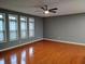 Living room with wood floors, a ceiling fan, and large windows at 1623 N College Ave # 2, Indianapolis, IN 46202