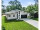 Modern home featuring a sleek design, dark garage door, striking windows, and a well-manicured lawn at 2689 Pearl St, Columbus, IN 47201