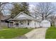 View of the home with an attached garage and a well-manicured lawn at 3000 Pearl St, Anderson, IN 46016