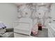 Bedroom showcasing floral wallpaper, white crib, and slate floors at 3659 Watson Rd, Indianapolis, IN 46205