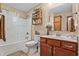 Clean bathroom with a shower-tub combo, a wooden vanity, and neutral-toned decor at 4857 W Congress Cv, New Palestine, IN 46163