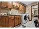 Well-equipped laundry room featuring cabinetry, a sink, and modern washer and dryer units at 4857 W Congress Cv, New Palestine, IN 46163