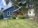 Charming home with blue siding, natural wood accents, and lush green landscaping at 5206 E St Clair St, Indianapolis, IN 46219