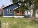 Charming home with blue siding, natural wood accents, and lush green landscaping at 5206 E St Clair St, Indianapolis, IN 46219