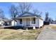 Charming single-story home featuring a cozy front porch, white siding, and long driveway at 613 S Mickley Ave, Indianapolis, IN 46241