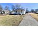 Quaint single-story home with inviting front porch, white siding, and spacious driveway at 613 S Mickley Ave, Indianapolis, IN 46241