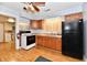Functional kitchen with white appliances, wooden cabinetry, and laminate flooring at 613 S Mickley Ave, Indianapolis, IN 46241