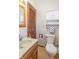 Classic bathroom with wood vanity, toilet, and striped wallpaper for a cozy feel at 6404 W Ray St, Indianapolis, IN 46241