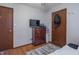 Bedroom showcasing hardwood floors, a dresser, and a door to another room at 6404 W Ray St, Indianapolis, IN 46241