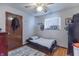 Bedroom features a single bed, hardwood floors, and natural light from the window at 6404 W Ray St, Indianapolis, IN 46241
