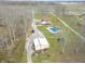 Expansive aerial view of property featuring a home, pool, and detached garage, surrounded by trees at 6602 S 400 W, Columbus, IN 47201