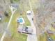 Stunning aerial view of property featuring a pool, detached garage and home with mature trees at 6602 S 400 W, Columbus, IN 47201