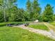 Backyard featuring fire pit and seating, set against a backdrop of mature trees at 6602 S 400 W, Columbus, IN 47201