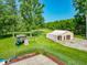 Large backyard featuring mature trees, a play set, and a metal outbuilding at 6602 S 400 W, Columbus, IN 47201