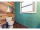 Stylish half bath with wood paneling accent wall, toilet, and window with natural light at 6602 S 400 W, Columbus, IN 47201