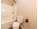 Bathroom featuring a white shower-tub combo with a bronze shower head and a white toilet at 6602 S 400 W, Columbus, IN 47201
