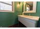 Bathroom featuring a white basin sink, bright green walls, and a window for natural light at 6602 S 400 W, Columbus, IN 47201