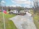 Aerial view of a brick home with a long driveway, detached garage, and American flag at 6602 S 400 W, Columbus, IN 47201