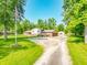 Spacious home with a gravel driveway, lush trees and an American flag at 6602 S 400 W, Columbus, IN 47201