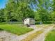 Exterior view of an outbuilding with fencing and a propane tank surrounded by mature trees at 6602 S 400 W, Columbus, IN 47201