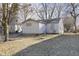 Exterior view of the home showcasing the backyard with a grassy lawn and mature trees at 715 S Ribble Ave, Muncie, IN 47302