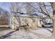 Cozy one-story home featuring a quaint front porch and a partially snow-covered yard at 715 S Ribble Ave, Muncie, IN 47302